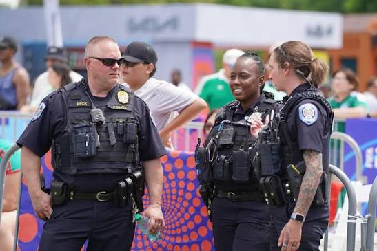 Two officers talking with attendees at a busy public event