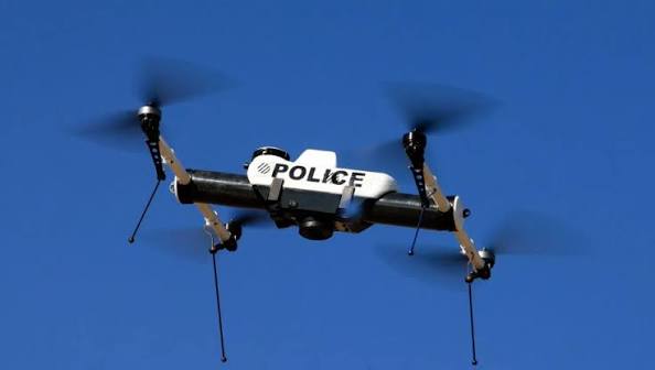 A KCPD police drone in flight against a blue sky
